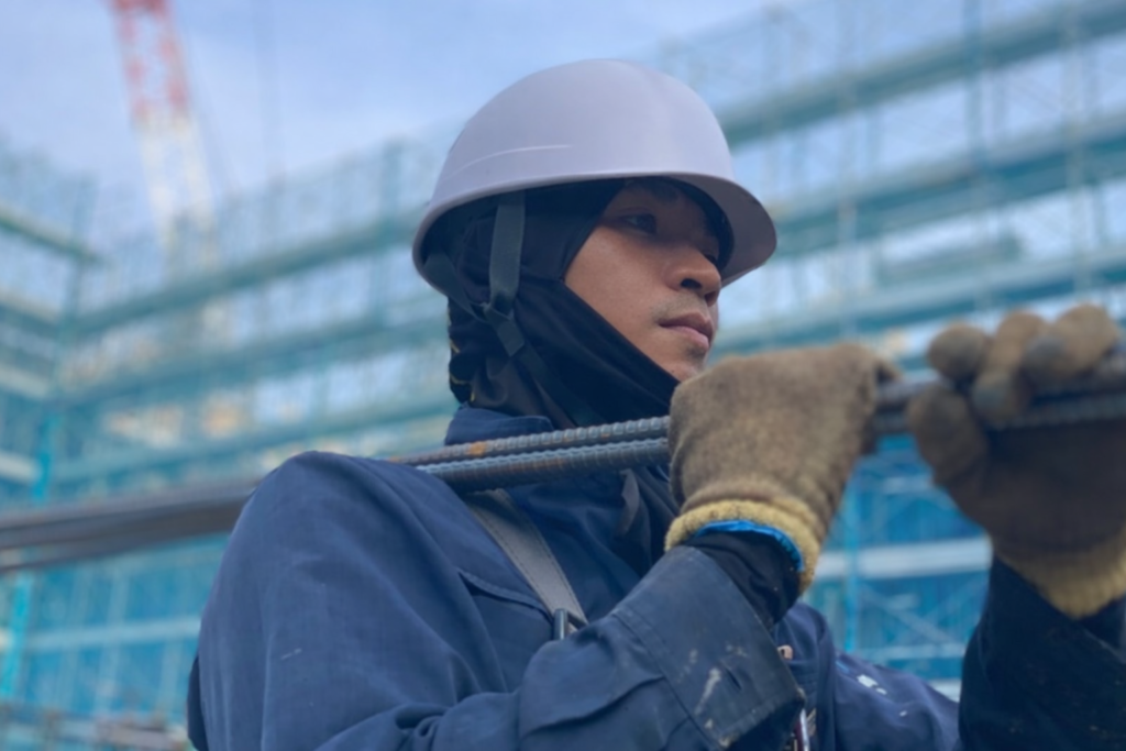 Myanmar construction worker handling materials at a building site in Japan
